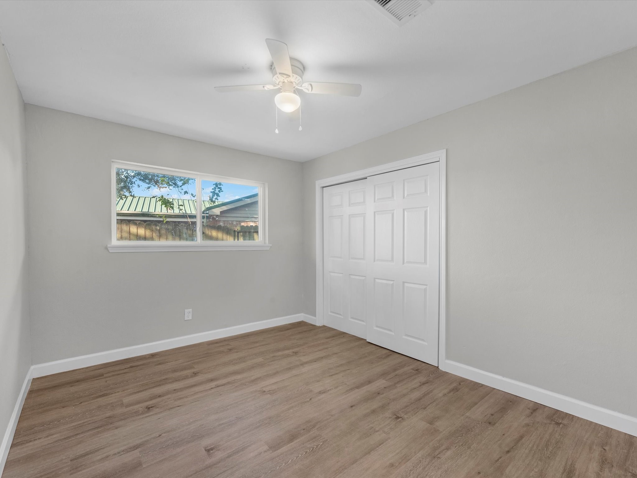 609 Debbie Lane Alvin, TX 77511 - Photo 17 of 32 a view of an empty room with wooden floor and a window
