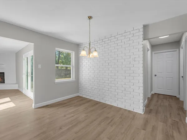 a view of an empty room with wooden floor and a ceiling fan