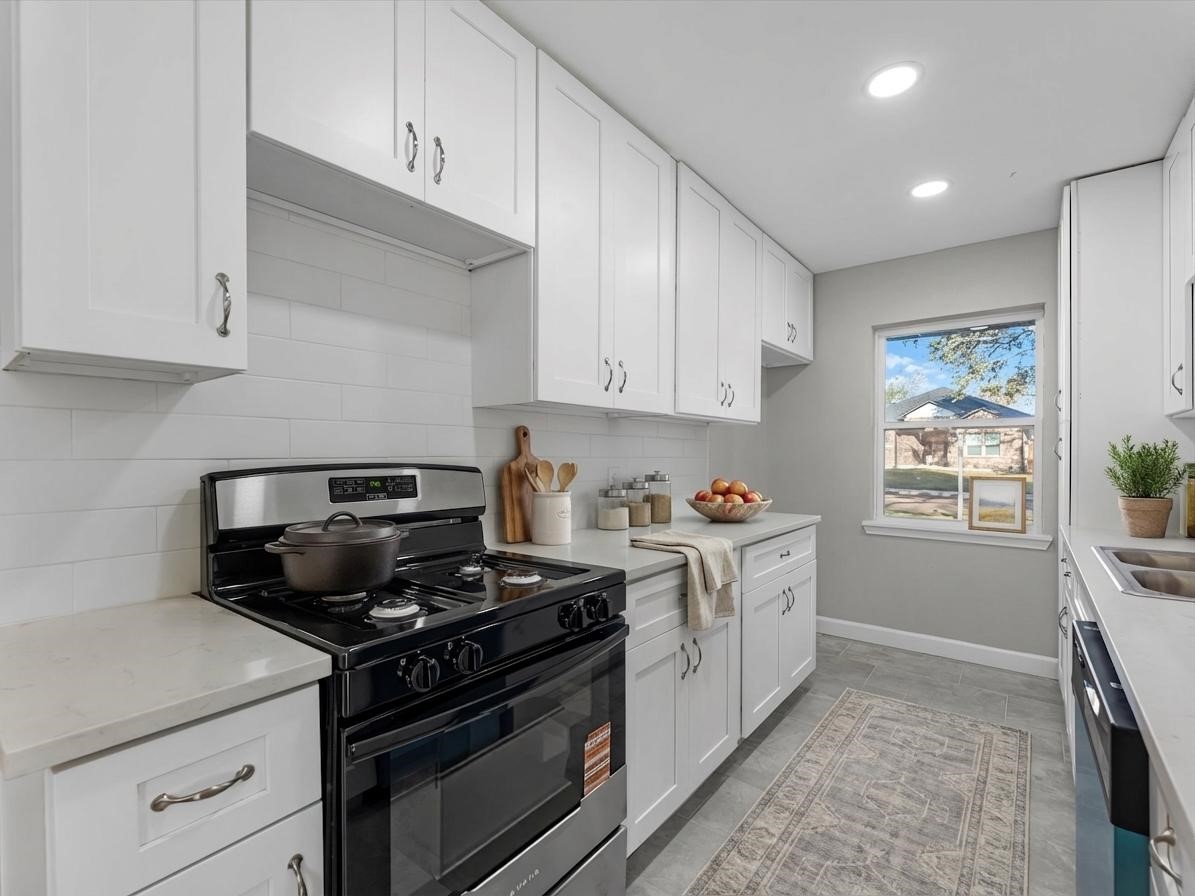 609 Debbie Lane Alvin, TX 77511 - Photo 6 of 32 a kitchen with a stove and white cabinets