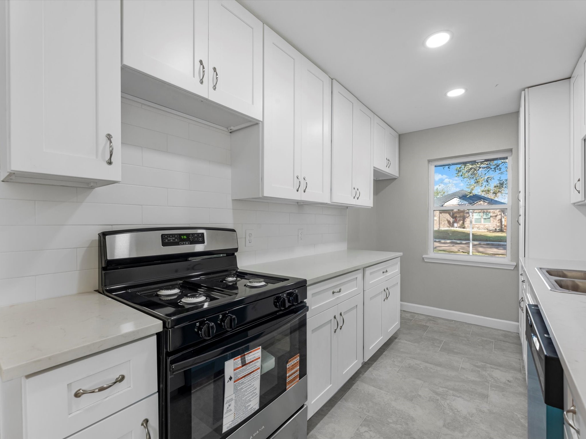 609 Debbie Lane Alvin, TX 77511 - Photo 7 of 32 a kitchen with stainless steel appliances a stove a sink and white cabinets