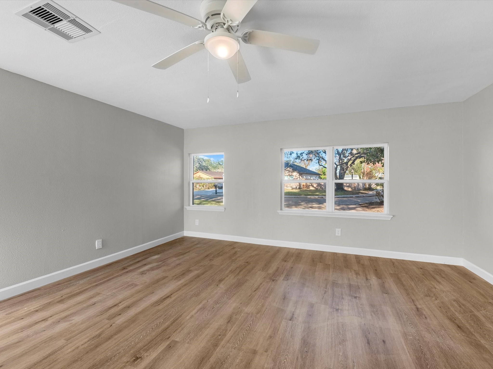 609 Debbie Lane Alvin, TX 77511 - Photo 8 of 23 an empty room with wooden floor chandelier fan and windows