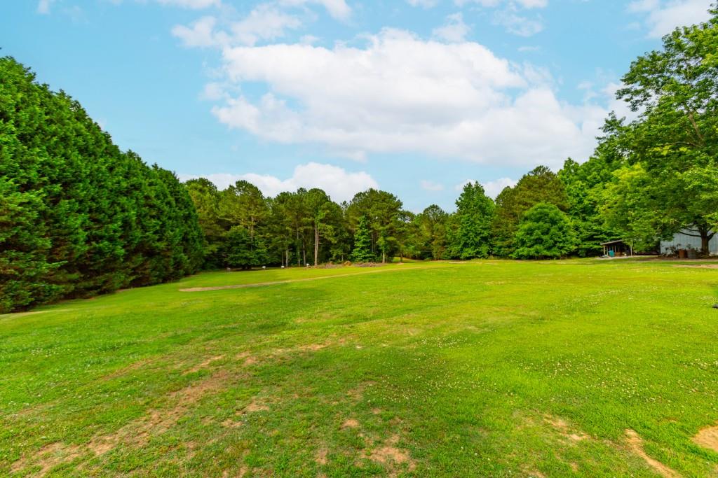 1042 Harbins Road Dacula, GA 30019 - Photo 23 of 35 a view of a green field with wooden fence