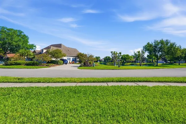 an aerial view of residential houses with outdoor space and trees