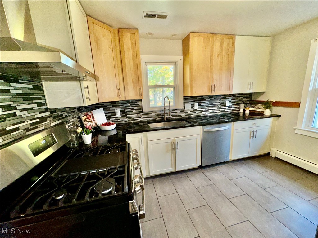 1729 East Pleasant Valley Road Independence, OH 44131 - Photo 18 of 41 Kitchen featuring sink, backsplash, exhaust hood, stainless steel dishwasher, and black range with gas cooktop