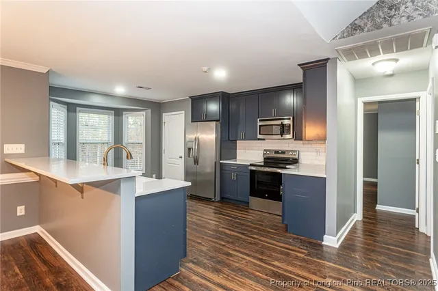 a large kitchen with stainless steel appliances kitchen island granite countertop a large counter top cabinets and stainless steel appliances