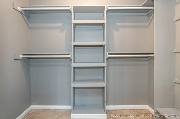 a view of walk in closet with empty racks