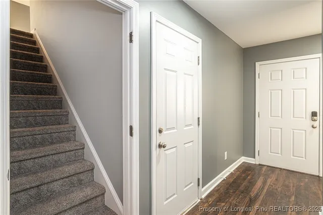 a view of a hallway with wooden floor and entryway