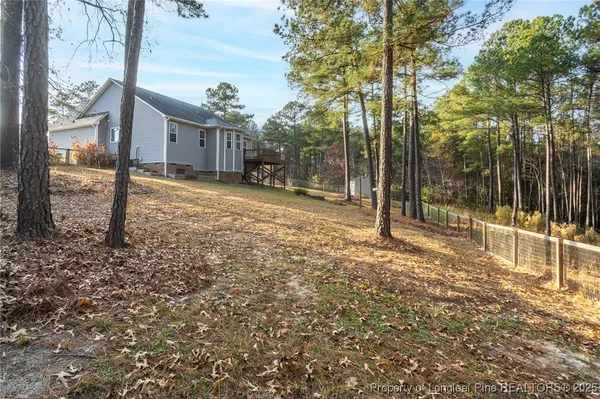 a view of a house with backyard and tree