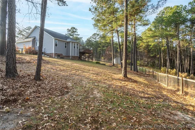 a view of a house with backyard and tree
