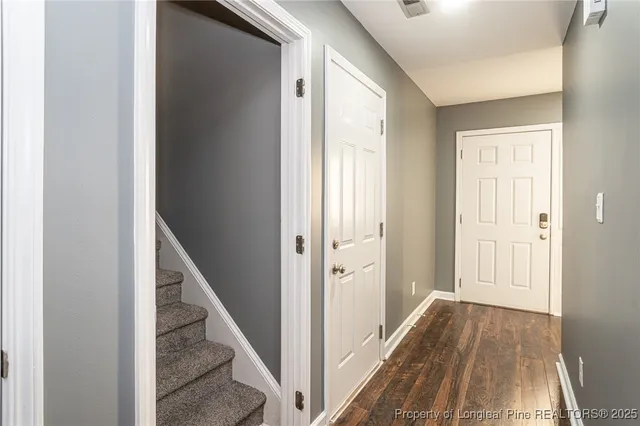 a view of a hallway with wooden floor and entryway
