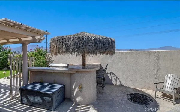 a backyard of a house with barbeque oven table and chairs