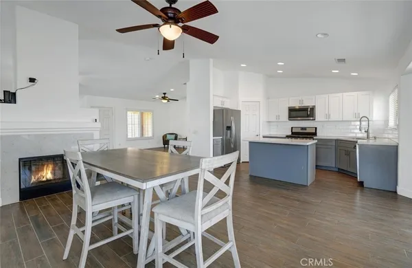 a kitchen with granite countertop stainless steel appliances a sink cabinets and wooden floor