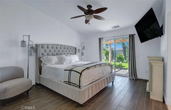 a bedroom with a bed a flat screen tv and a couch