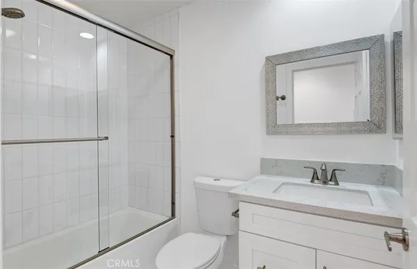 a bathroom with a toilet sink vanity and shower