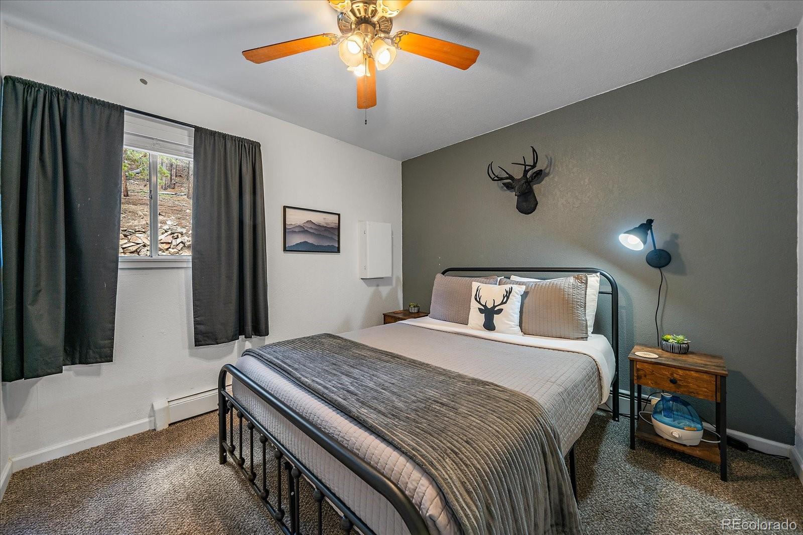 136 Nebraska Drive Idaho Springs, CO 80452 - Photo 11 of 29 a bedroom with a large bed and a chandelier