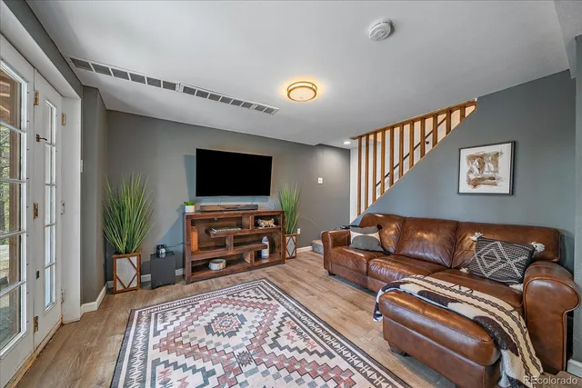 a living room with furniture a piano and wooden floor