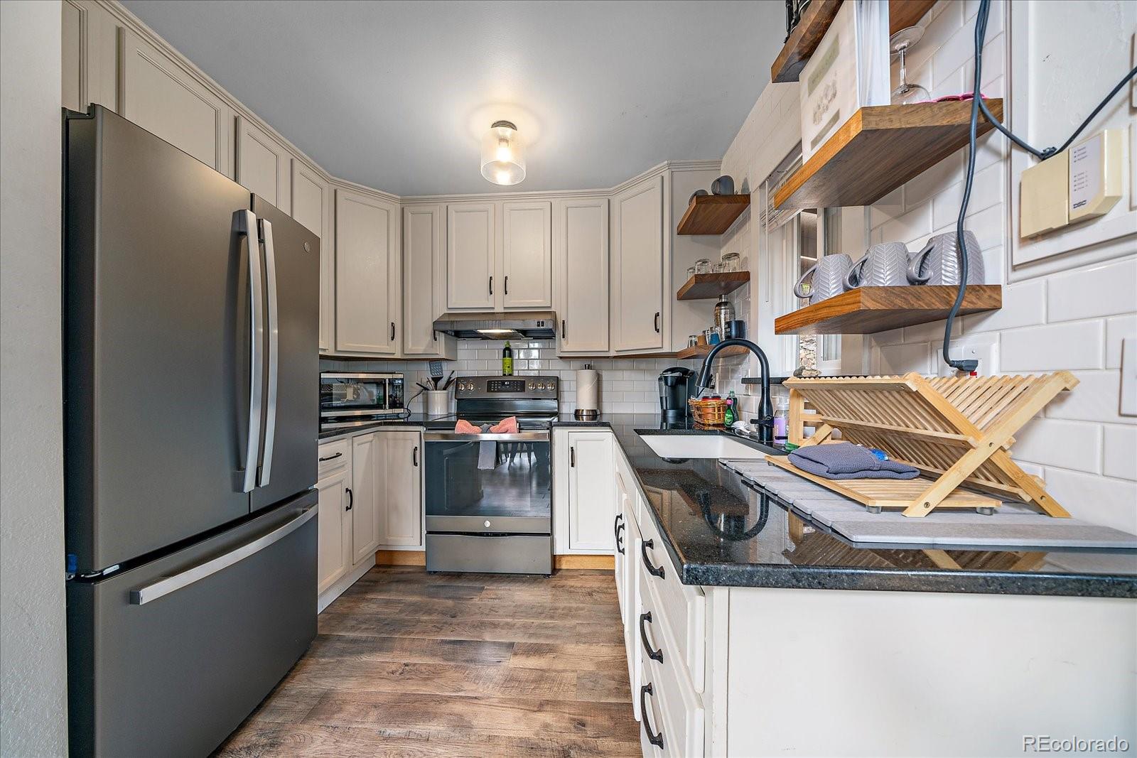 136 Nebraska Drive Idaho Springs, CO 80452 - Photo 9 of 29 a kitchen with stainless steel appliances granite countertop a refrigerator a stove and a sink