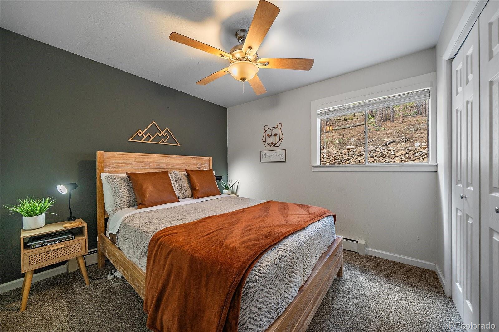 136 Nebraska Drive Idaho Springs, CO 80452 - Photo 10 of 29 a bedroom with a bed and a chandelier