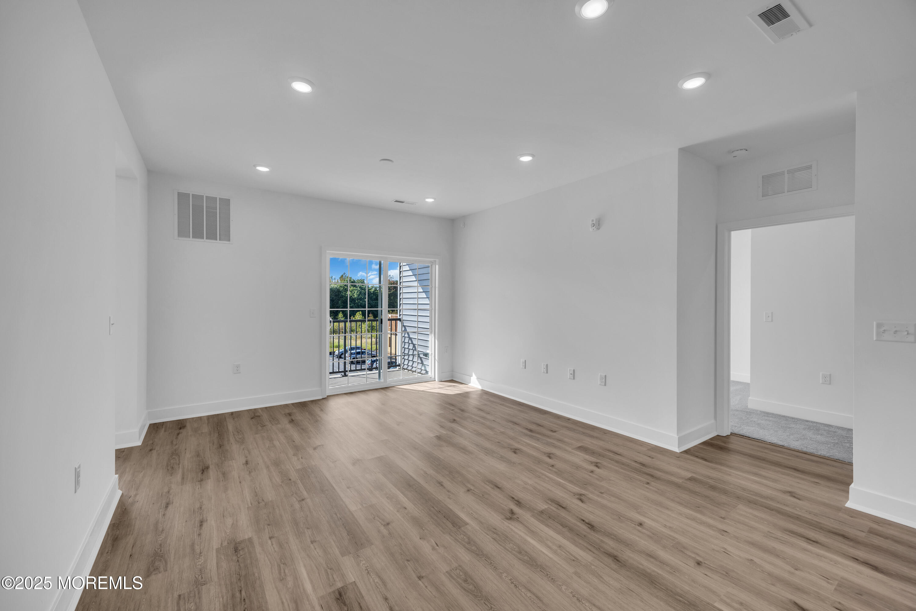 28311 Radford Court, Unit 2829 Monroe Township, NJ 08831 - Photo 14 of 29 a view of an empty room with wooden floor and a window