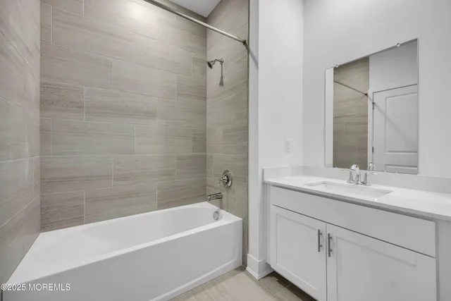 a bathroom with a tub sink and mirror