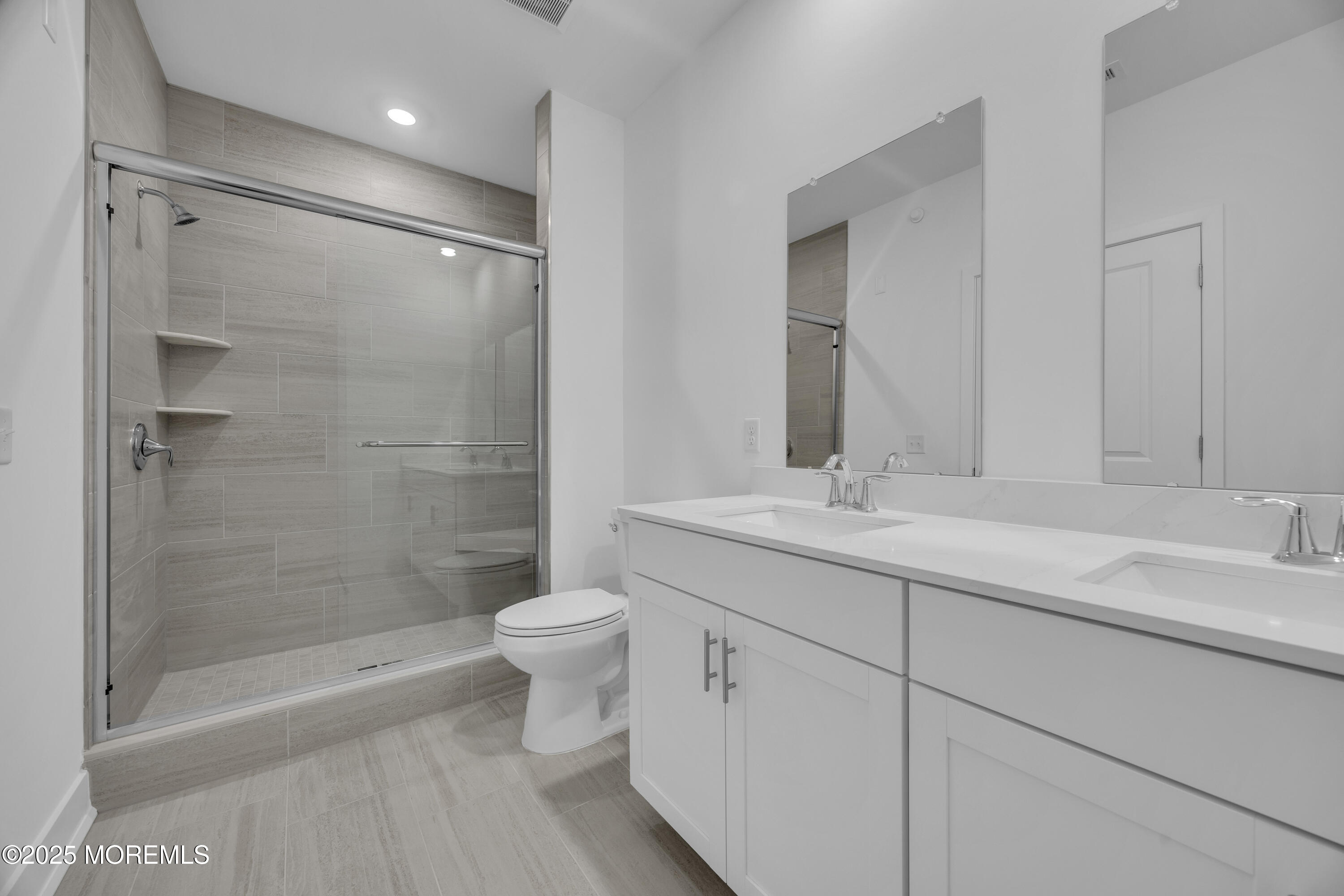28311 Radford Court, Unit 2829 Monroe Township, NJ 08831 - Photo 27 of 29 a bathroom with a shower sink vanity mirror and toilet