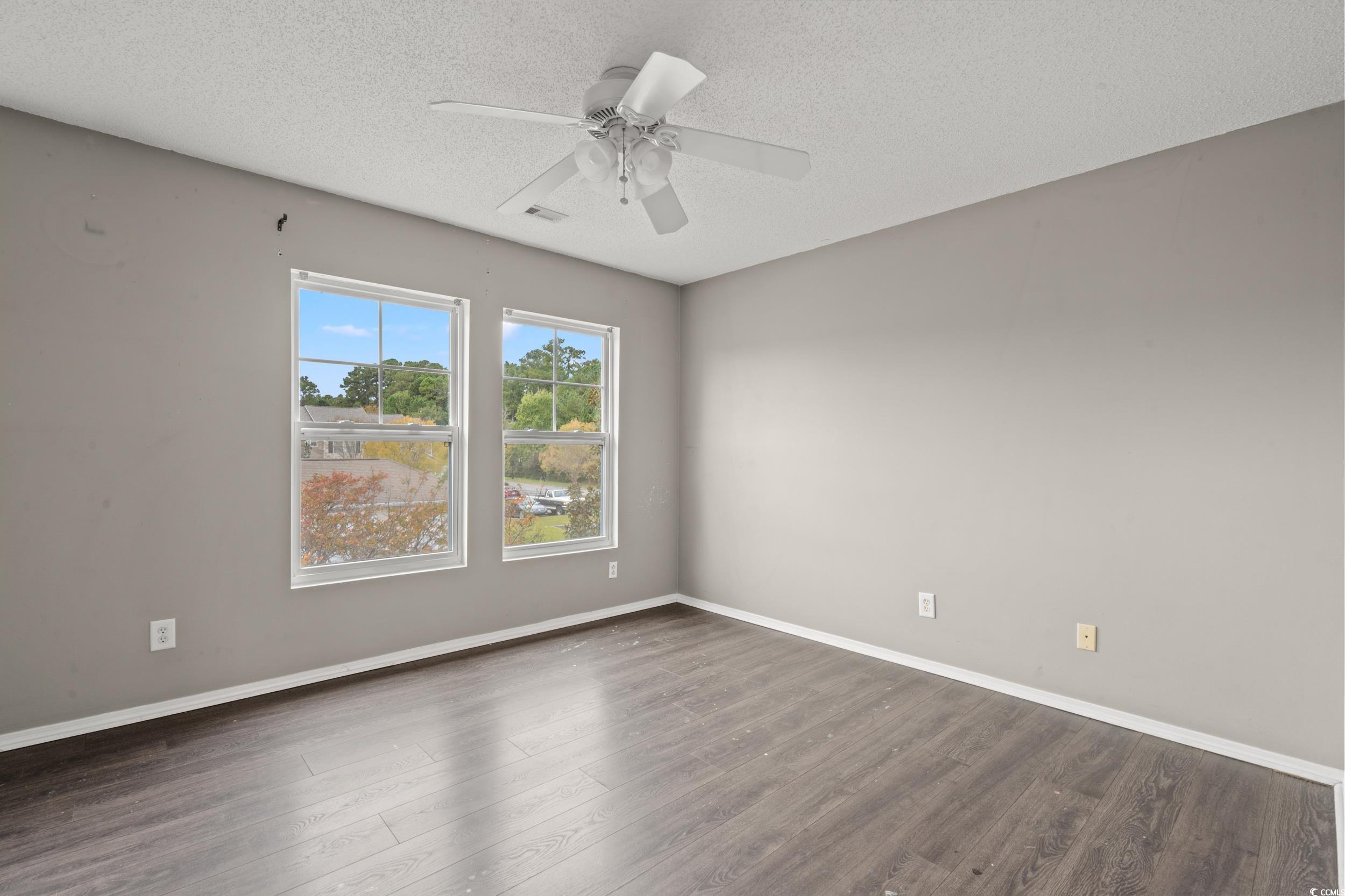 322 Kiskadee Loop, Unit 12E Conway, SC 29526 - Photo 15 of 36 Unfurnished room with a textured ceiling, wood finished floors, and a ceiling fan