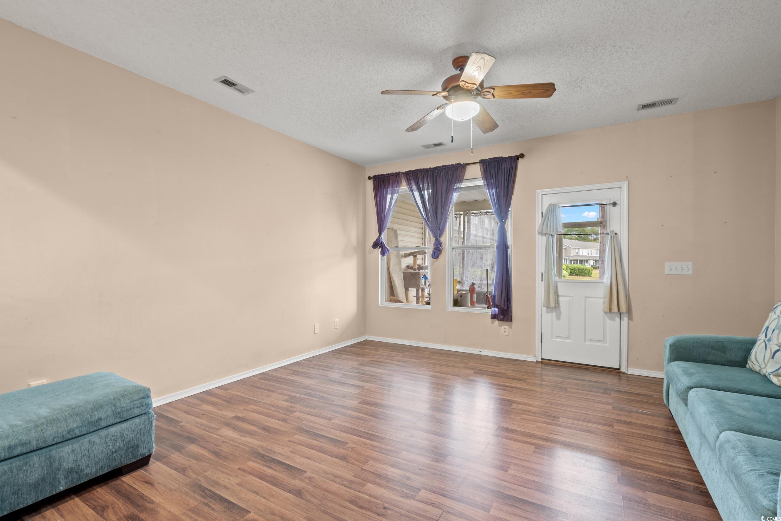 322 Kiskadee Loop, Unit 12E Conway, SC 29526 - Photo 8 of 36 Living area featuring wood finished floors, a textured ceiling, and ceiling fan