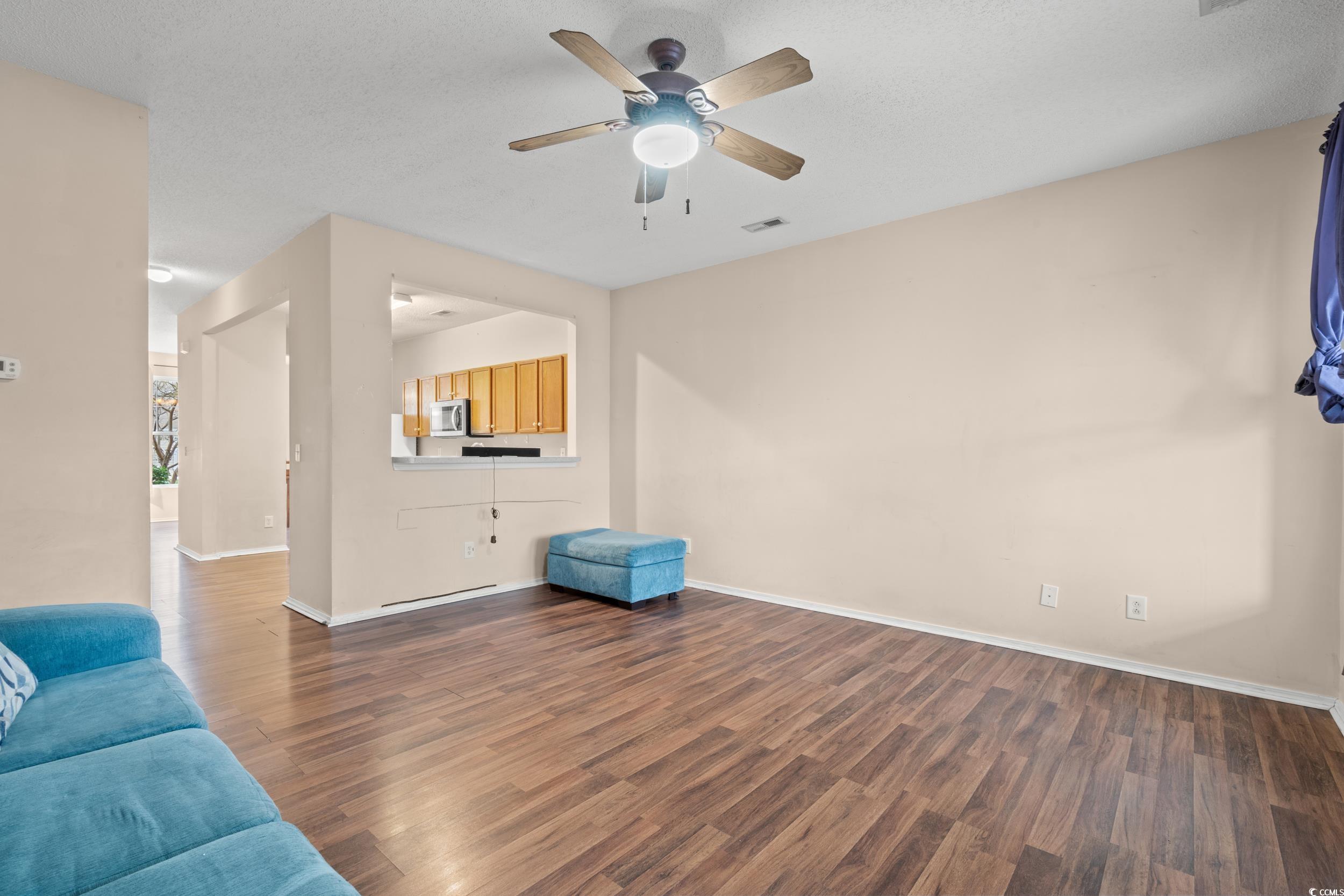 322 Kiskadee Loop, Unit 12E Conway, SC 29526 - Photo 9 of 36 Living area featuring dark wood-type flooring, a ceiling fan, and a textured ceiling