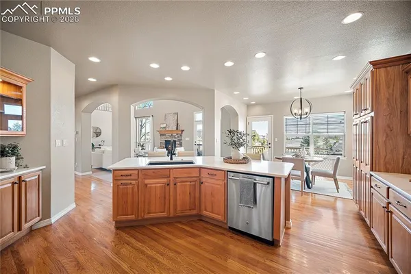 a large kitchen with cabinets chairs and wooden floor
