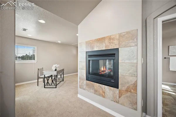 a living room with furniture a fireplace and a floor to ceiling window