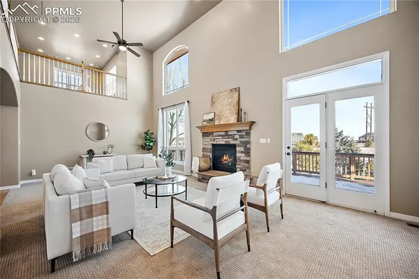 a living room with furniture a fireplace and a chandelier