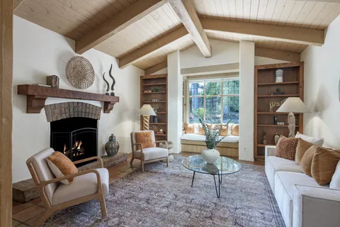 a living room with furniture a fireplace and a large window