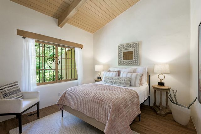 a bedroom with a bed a lamps and a large window