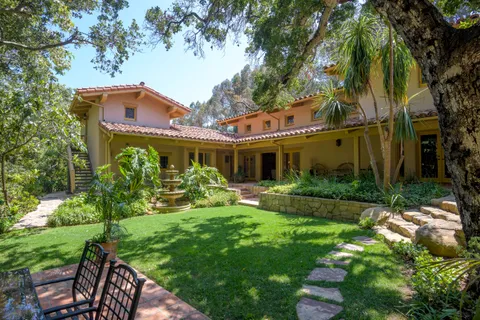 a front view of a house with yard and green space
