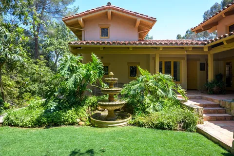 a front view of a house with a yard and potted plants