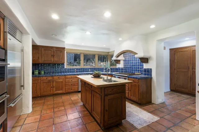 a kitchen with granite countertop a sink and a refrigerator