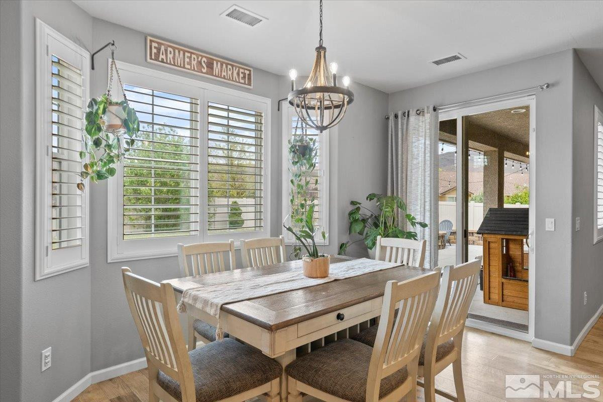 2265 Renzo Way Reno, NV 89521 - Photo 8 of 24 a dining room with furniture large windows and a chandelier