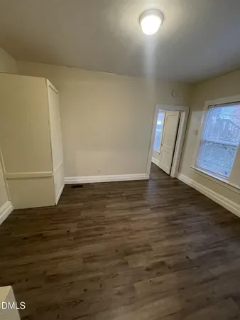 a view of an empty room with wooden floor