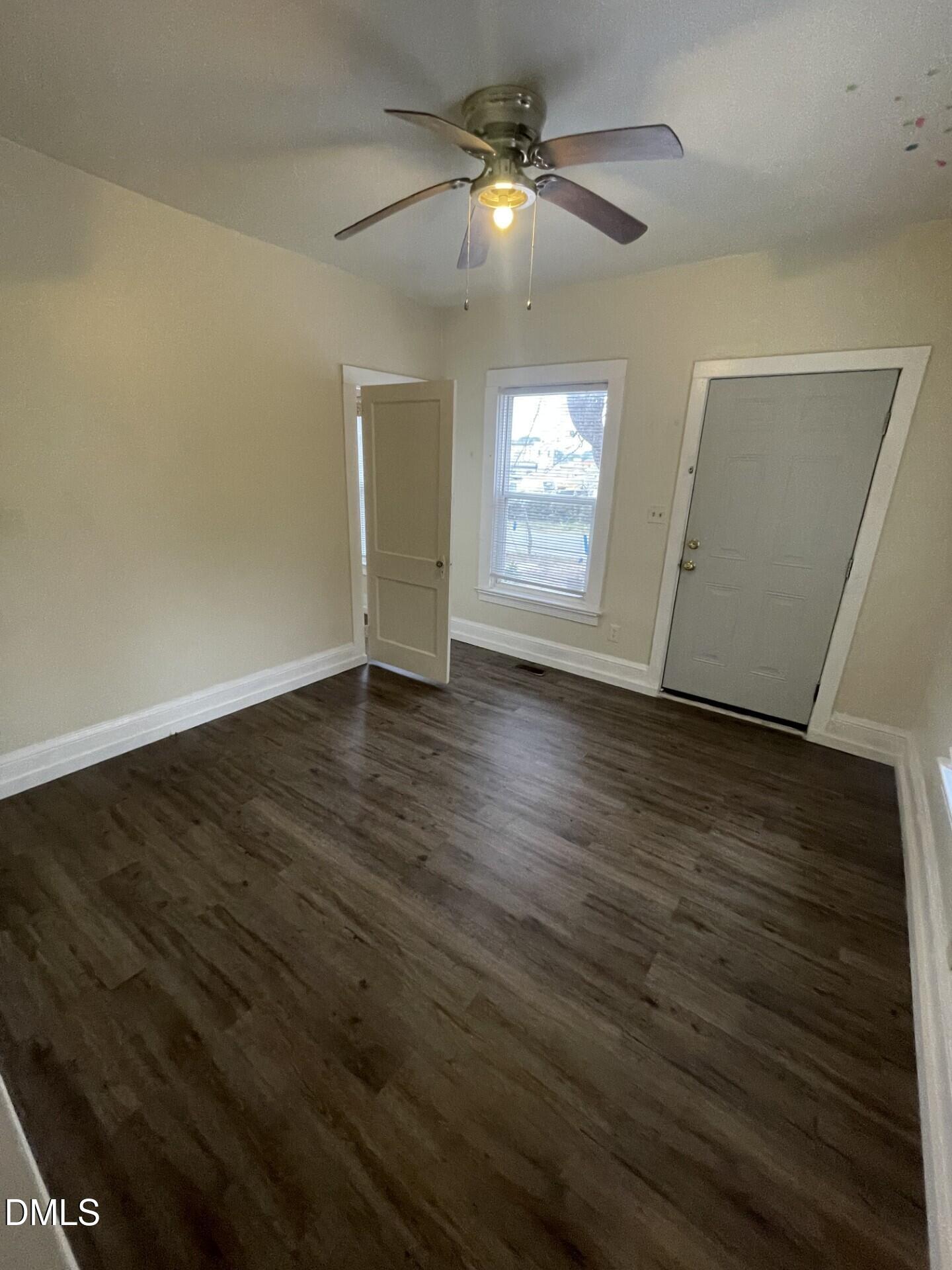 305 Kennedy Street Raleigh, NC 27610 - Photo 5 of 13 an empty room with wooden floor fan and window