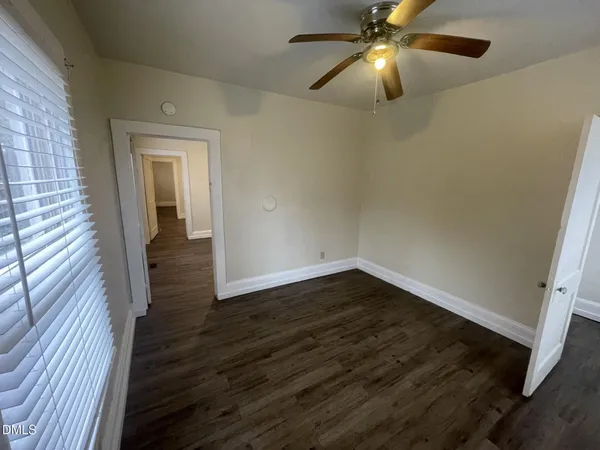 a view of empty room with wooden floor