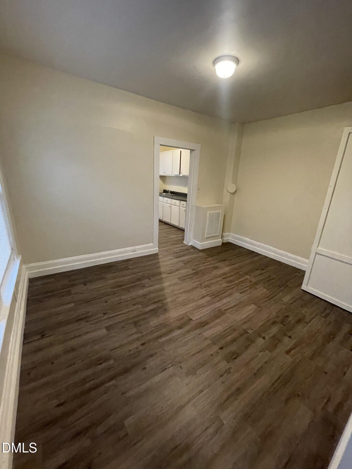 305 Kennedy Street Raleigh, NC 27610 - Photo 10 of 13 an empty room with wooden floor and windows