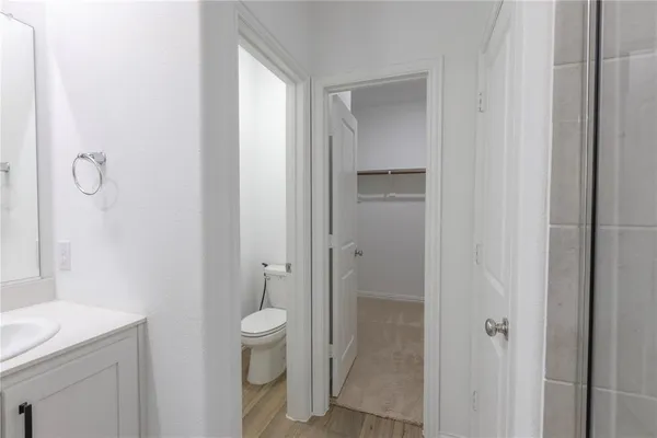 a bathroom with a granite countertop sink a toilet and shower