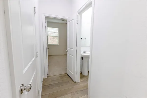 a view of a hallway with wooden floor and closet