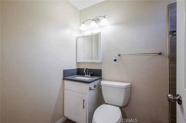 a bathroom with a toilet a sink and mirror