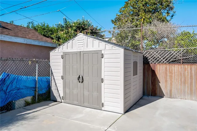 a view of backyard with small cabin and wooden fencing