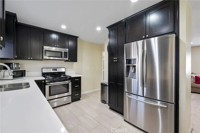 a metallic refrigerator freezer sitting in a kitchen