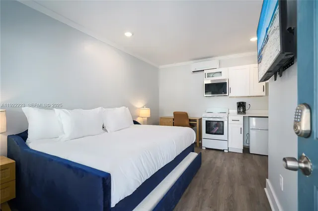 a large bedroom with bed and a flat tv screen on the dresser