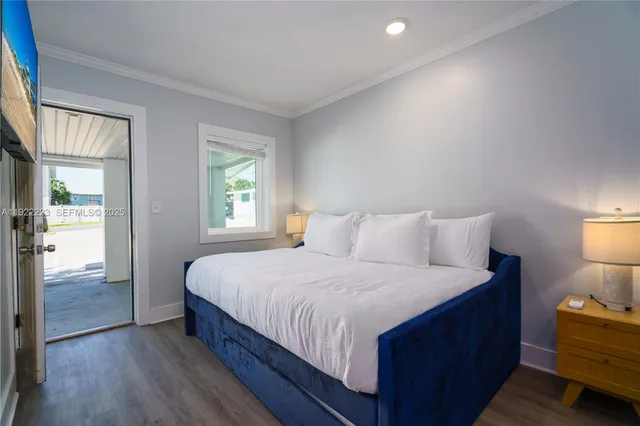 a bedroom with a bed and a lamp on dresser