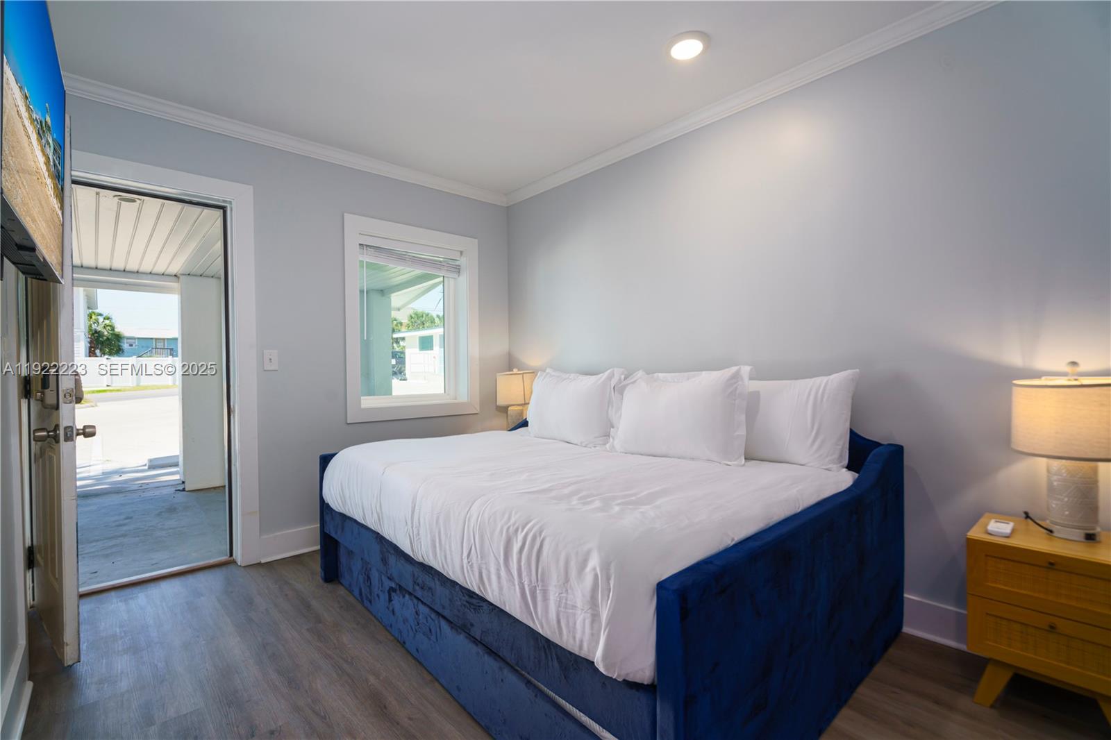 17784 Front Beach Road, Unit 10 Panama City, FL 32413 - Photo 3 of 12 a bedroom with a bed and a lamp on dresser