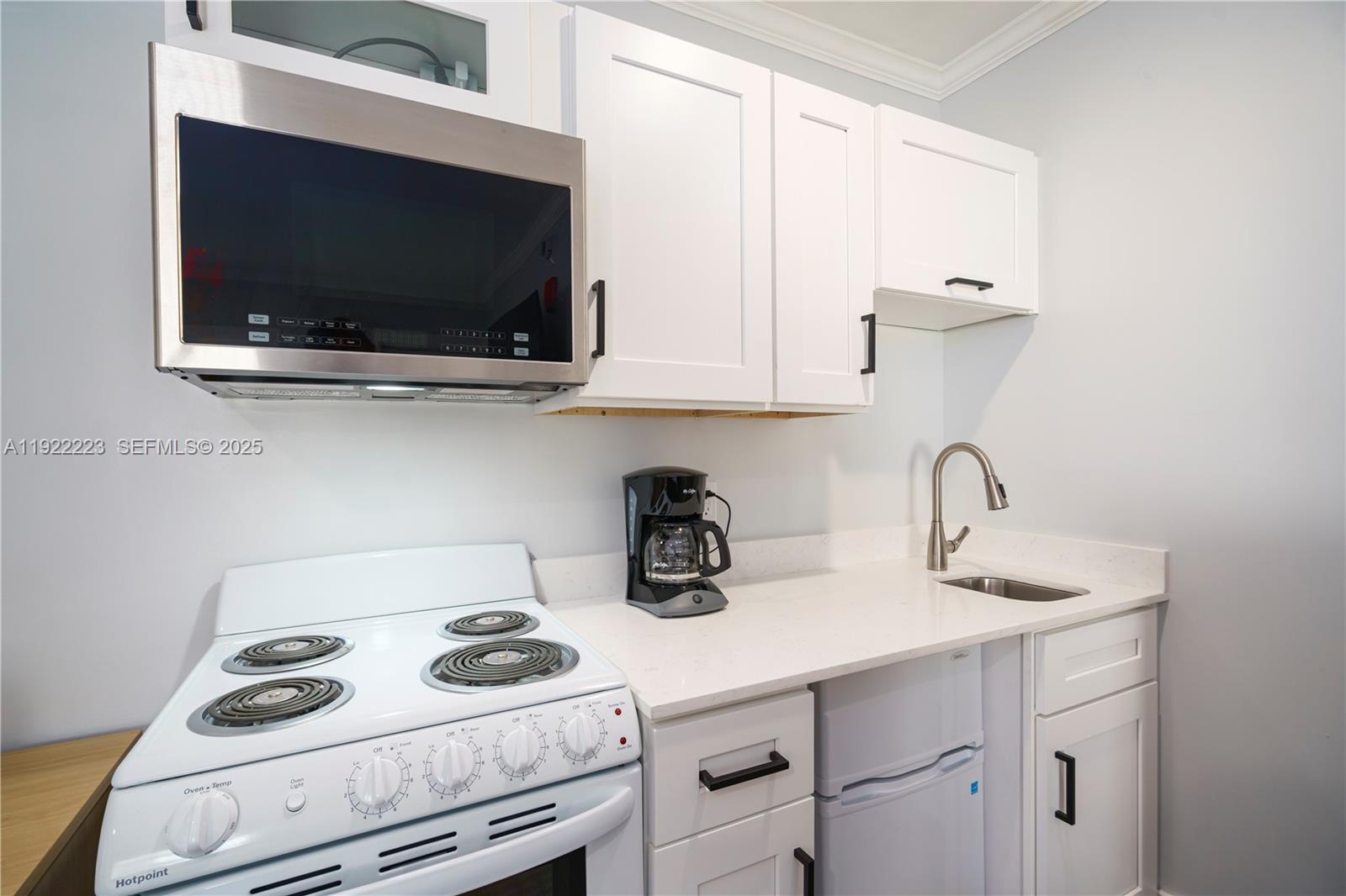 17784 Front Beach Road, Unit 10 Panama City, FL 32413 - Photo 5 of 12 a kitchen with a stove and a microwave
